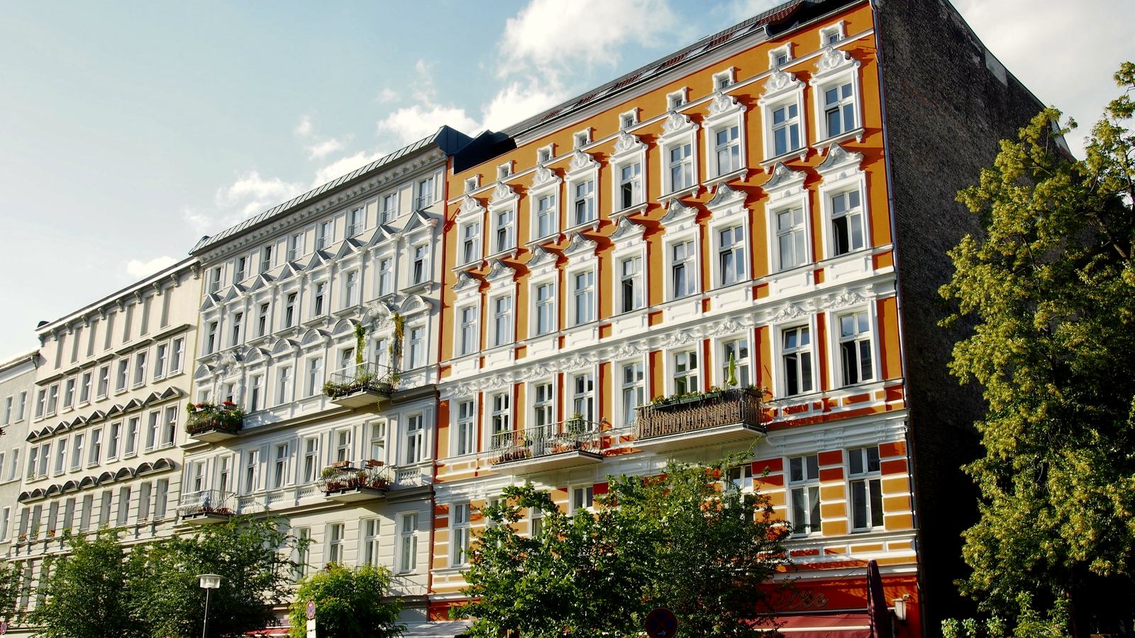 Farbig gestaltete Berliner Altbauzeile mit Bäumen